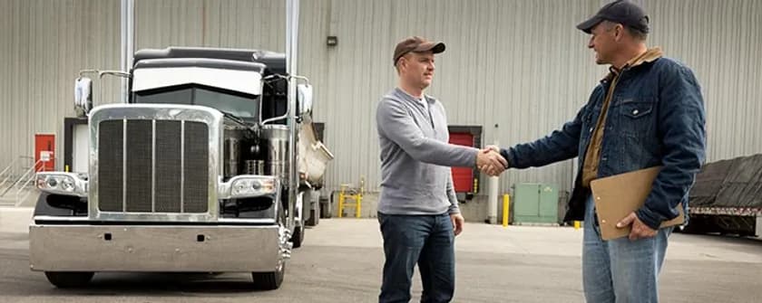 An Interstate Fleet Services representative shaking hands with a driver