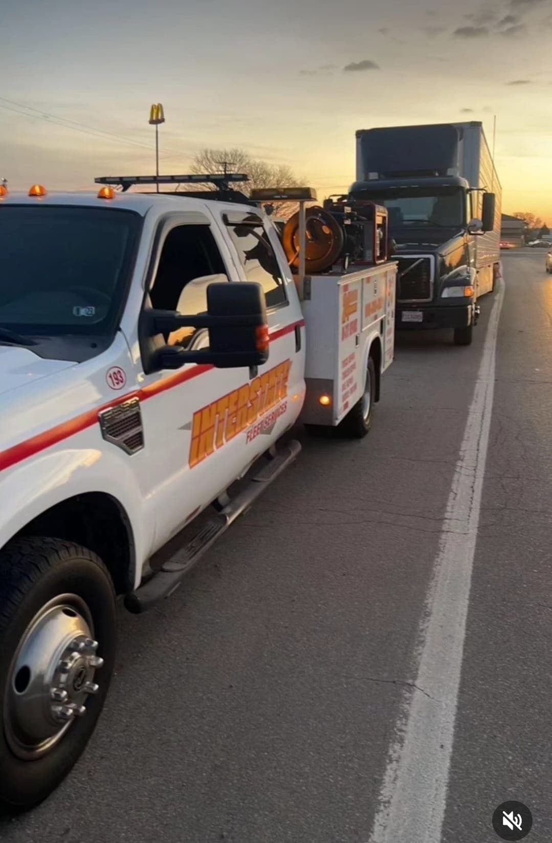 An Interstate Fleet Services truck on the highway at golden hour, following freight