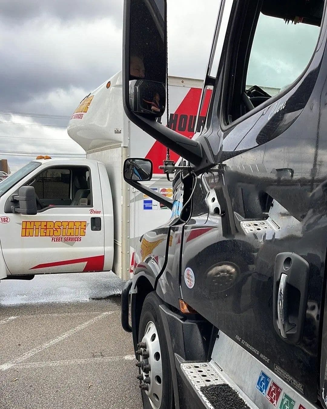 Interstate Fleet Services technician's truck parked beside a tractor for an on-site repair