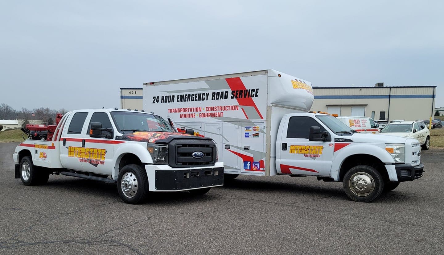 Two Interstate Fleet Services 24-hour emergency road service trucks staged at a facility
